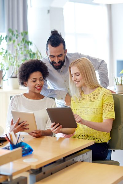 business, technology, startup and people concept - happy creative team with tablet pc computers in office